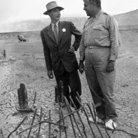 Oppenheimer and Groves examine the remains of one the bases of the steel test tower